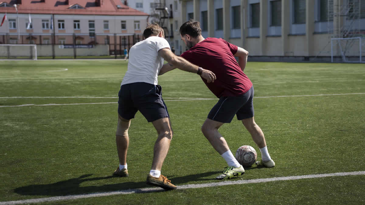 full shot men playing soccer