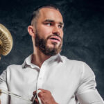 cheeky handsome in man white shirt with golden boxing glove is standing | dark studio | magnific | 26605858
